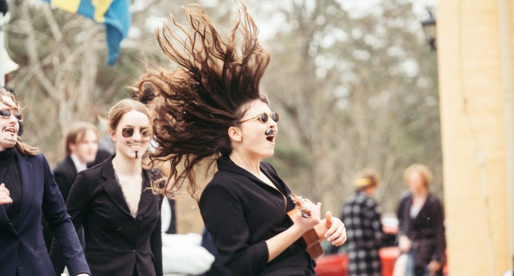 Några utklädda tjejer sjunger och spexar på skolområdet