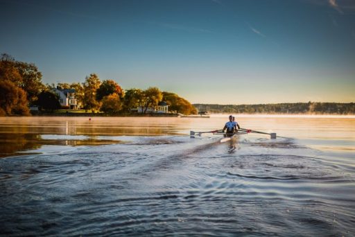 Elev som ror över Mälarens stilla vatten, nedanför skolan