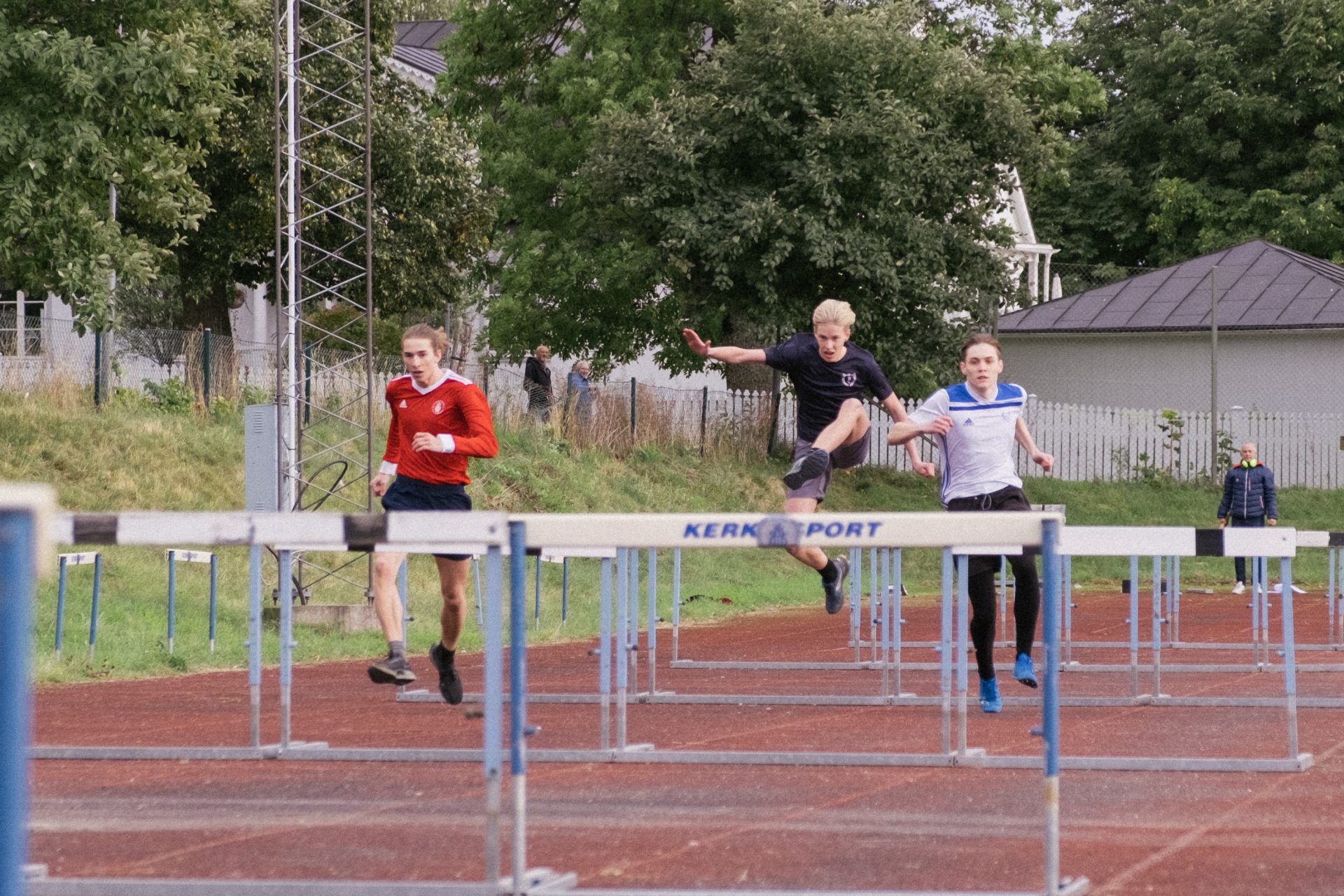 Två elever hoppar häck på skolans idrottsplats